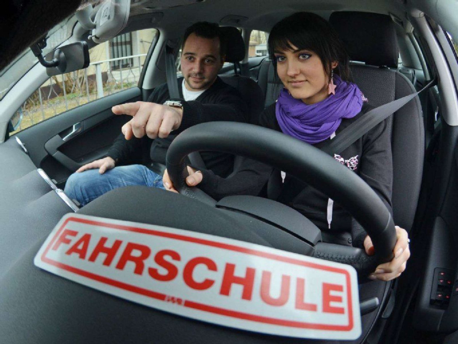 Fahrlehrer begleitet eine Fahrschülerin während einer Übungsfahrt