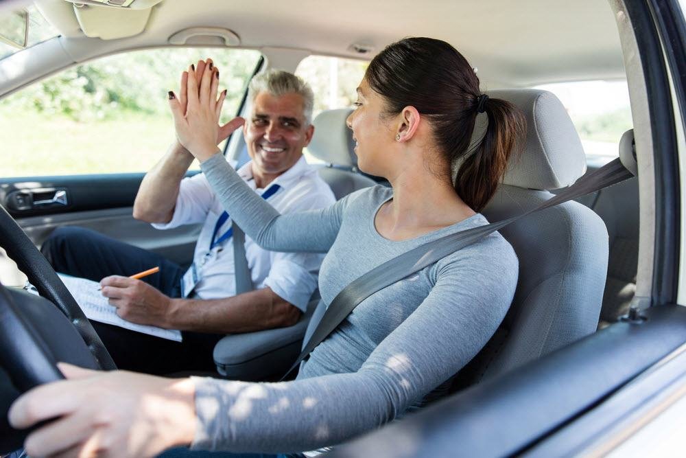 Fahrlehrer begleitet eine Fahrschülerin während einer Übungsfahrt